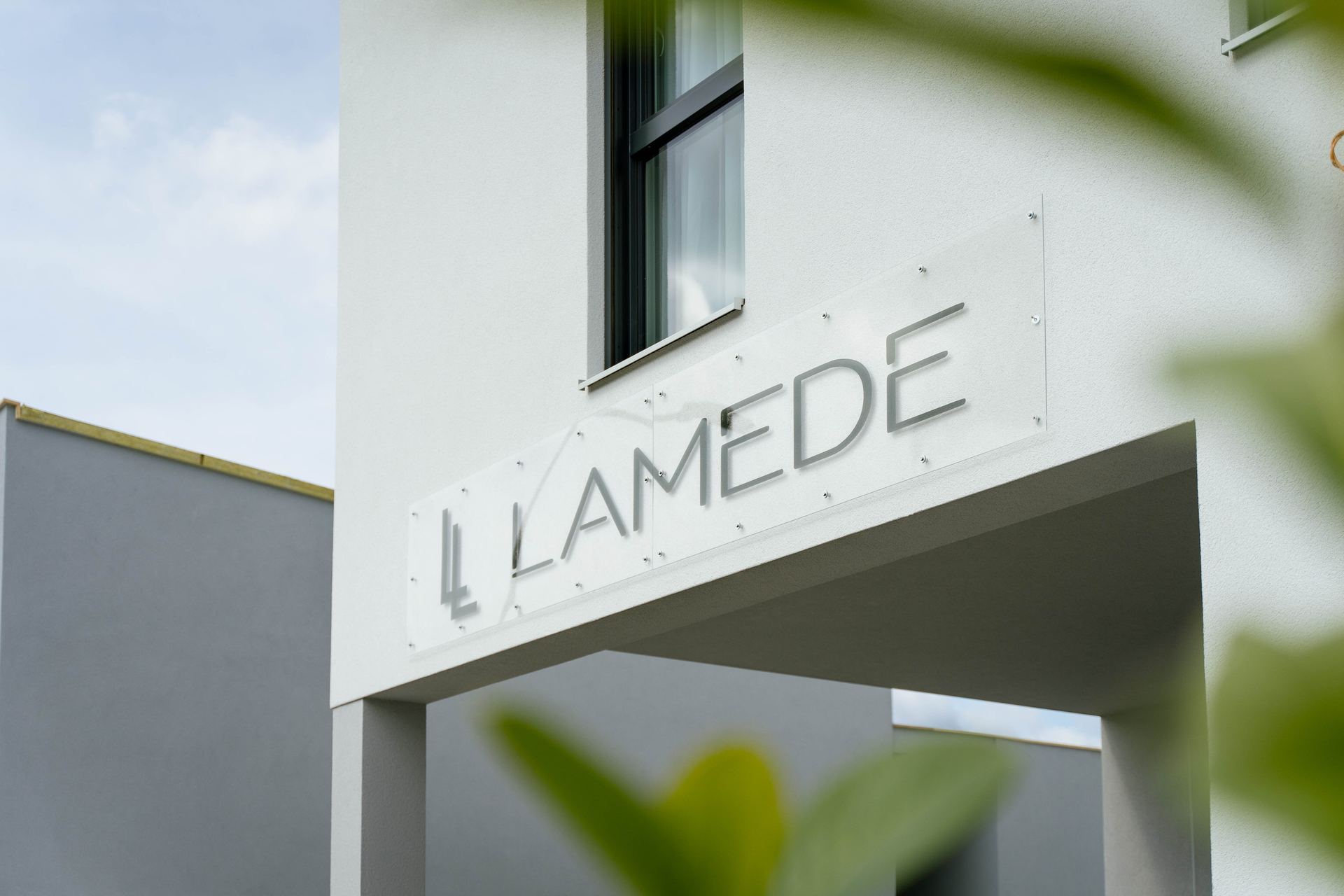 Eingang des Hotel Lamede mit Schild und Pflanzen
